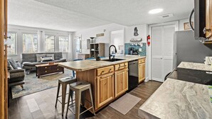 Une cuisine moderne dotée d’un grand îlot central, de meubles en bois et d’un lave-vaisselle encastré.