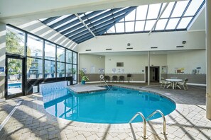 An indoor swimming pool with a skylight, a poolside area with chairs, and a view of the outside. - 2BD/2BA in Five Seasons, Myrtle Beach Resort. (Myrtle Beach)