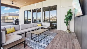 A modern outdoor living area with a sofa, coffee table, and a potted plant. - Trendy 1BR w/ 10ft Ceilings+FREE Parking+ Pets OK (Dallas)