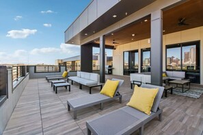 A rooftop terrace with outdoor seating, a city view, and a modern architectural design. - Trendy 1BR w/ 10ft Ceilings+FREE Parking+ Pets OK (Dallas)