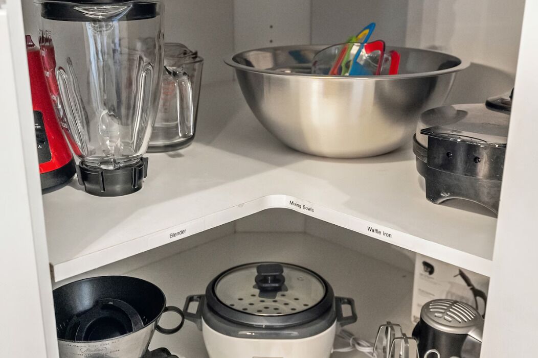 Una cocina con licuadora, bowls para mezclar y una plancha para gofres.