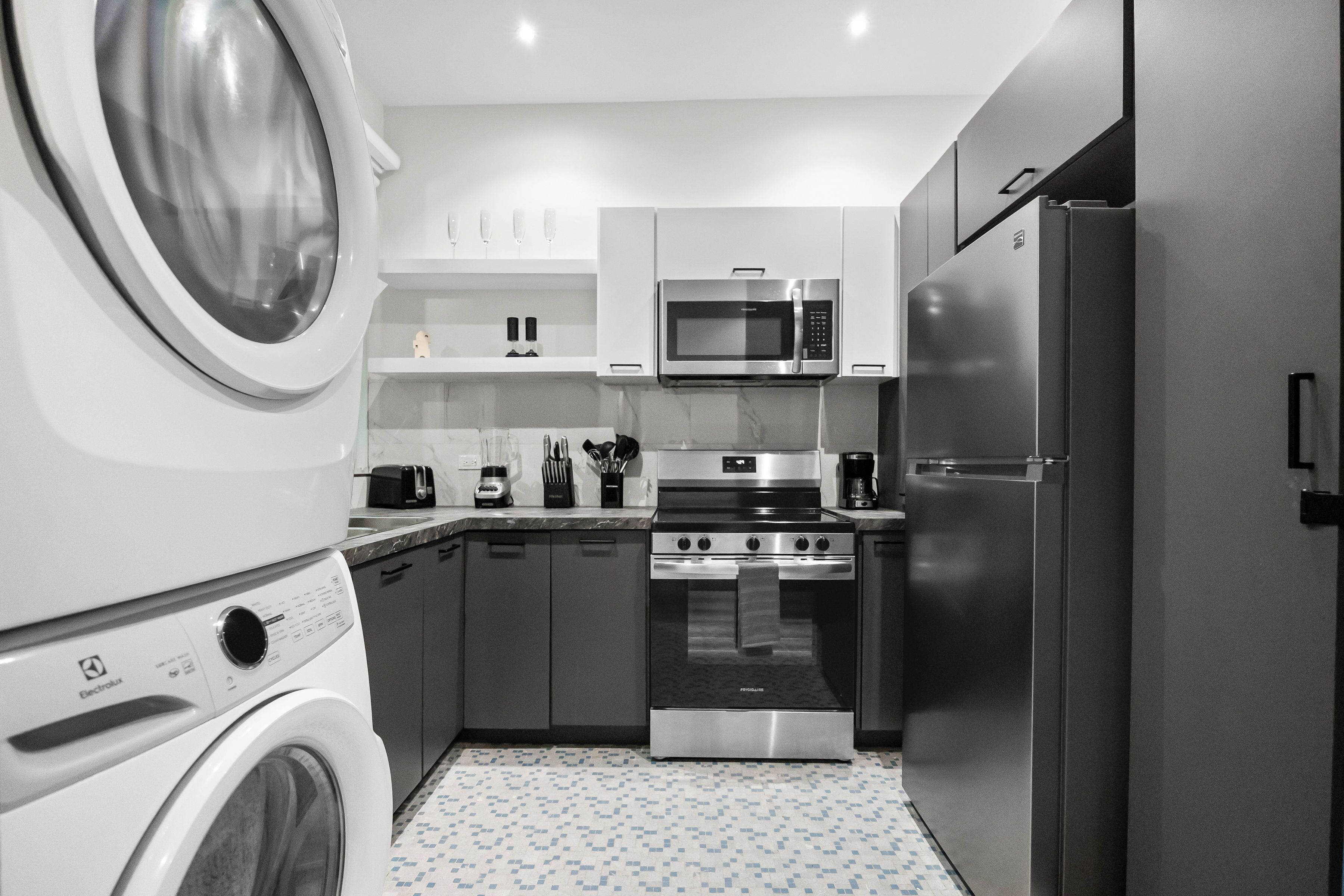 Cocina compacta equipada con lavadora, microondas, horno y refrigerador.