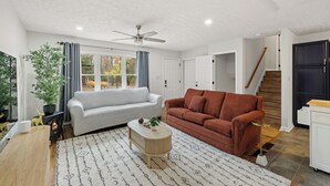 A living room with a white sofa, a brown sofa, a wooden coffee table, and a ceiling fan. - Red Fox Den-Year Round Retreat At Massanutten- Ski, Bike, Golf, Hike & Waterpark (McGaheysville)