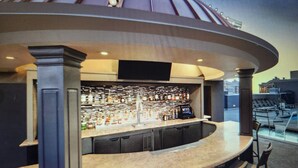 A bar area with a curved counter, multiple stools, and a wall of liquor bottles. - Steps from the Las Vegas Strip Perfect Condo for National Rodeo Finals Event (Las Vegas)