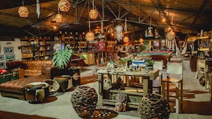 A rustic interior with exposed beams, hanging lamps, and a variety of decorative items. - Cerro Tusa Glamping  (Titiribí)