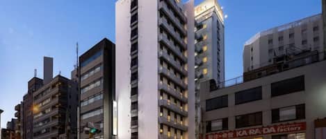A multi-story hotel with a modern design, featuring a prominent vertical structure and a ground-level restaurant.