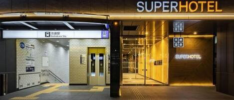 The entrance to a hotel with a modern design, featuring a prominent 'SuperHotel' sign.