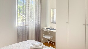 Ein Schlafzimmer mit einem Bett, einem Schreibtisch, einem Stuhl und einem Kleiderschrank.
