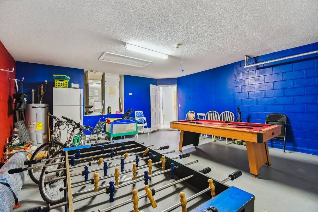 Una habitación con mesa de fútbol, bicicletas y mesa de billar.