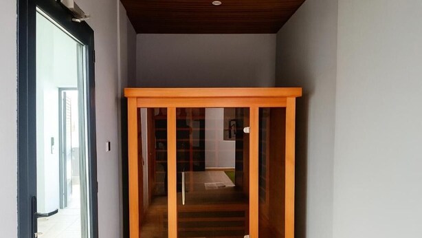 Un pasillo con una puerta de madera que da a una habitación.