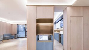 Un intérieur moderne avec un espace salon central, un comptoir de service intégré et une vue à travers une porte vitrée.