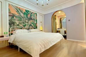 A bedroom with a bed, a large wall mural, a mirror, and a wooden floor. - Longteng Hotel (Dehua)