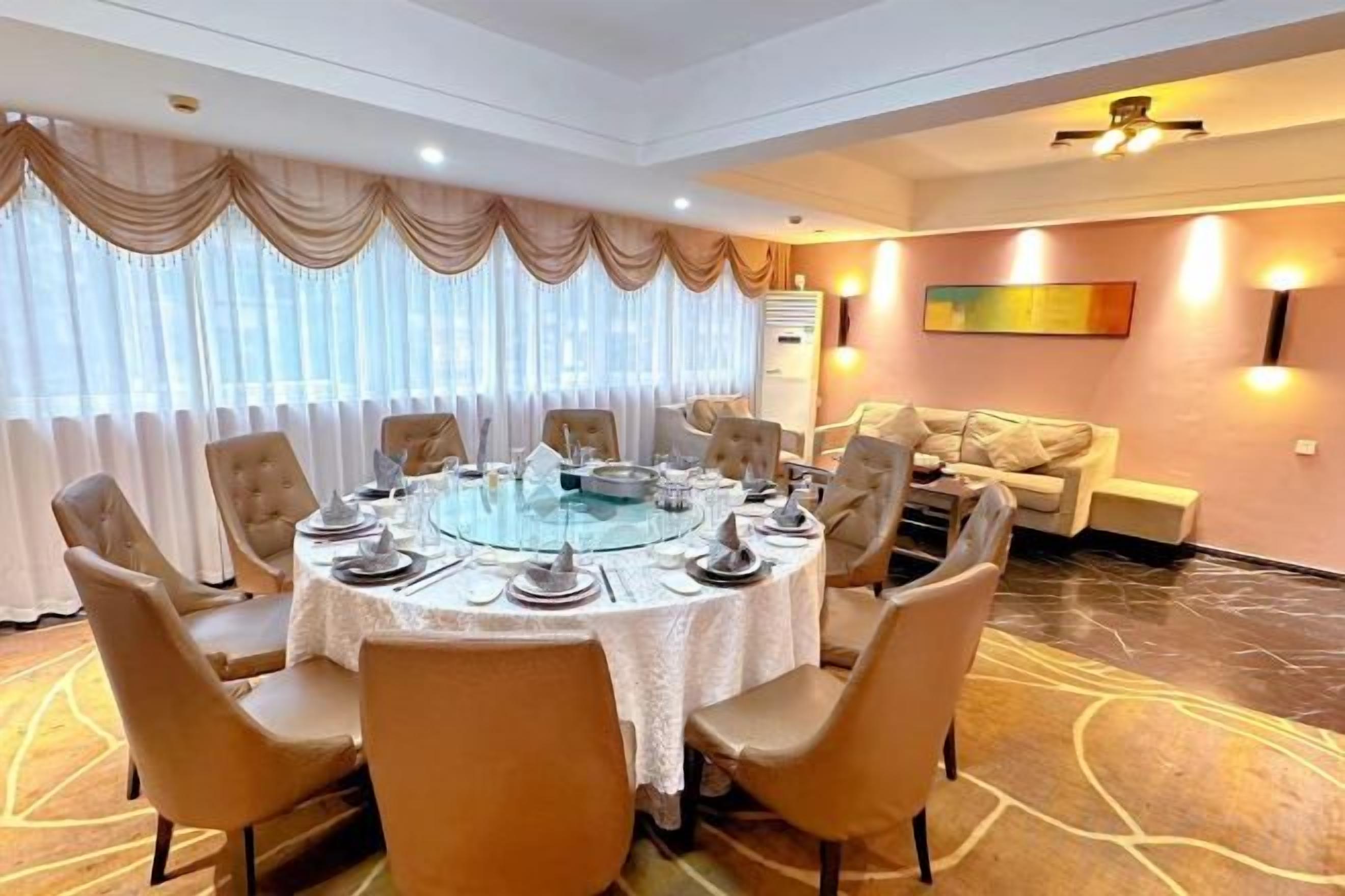 A conference room with a round table, chairs, and a sofa.
