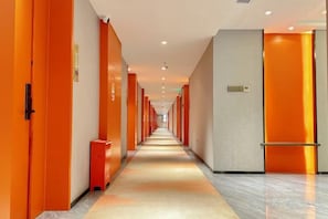 A long, narrow hotel corridor with doors on both sides, a light-colored floor, and a bright ceiling. - Longteng Hotel (Dehua)