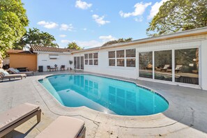 Una piscina con lettini e una zona prendisole.