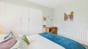 A bedroom with a bed, a desk, and a radiator. - Host Stay Highgarth (Seahouses)