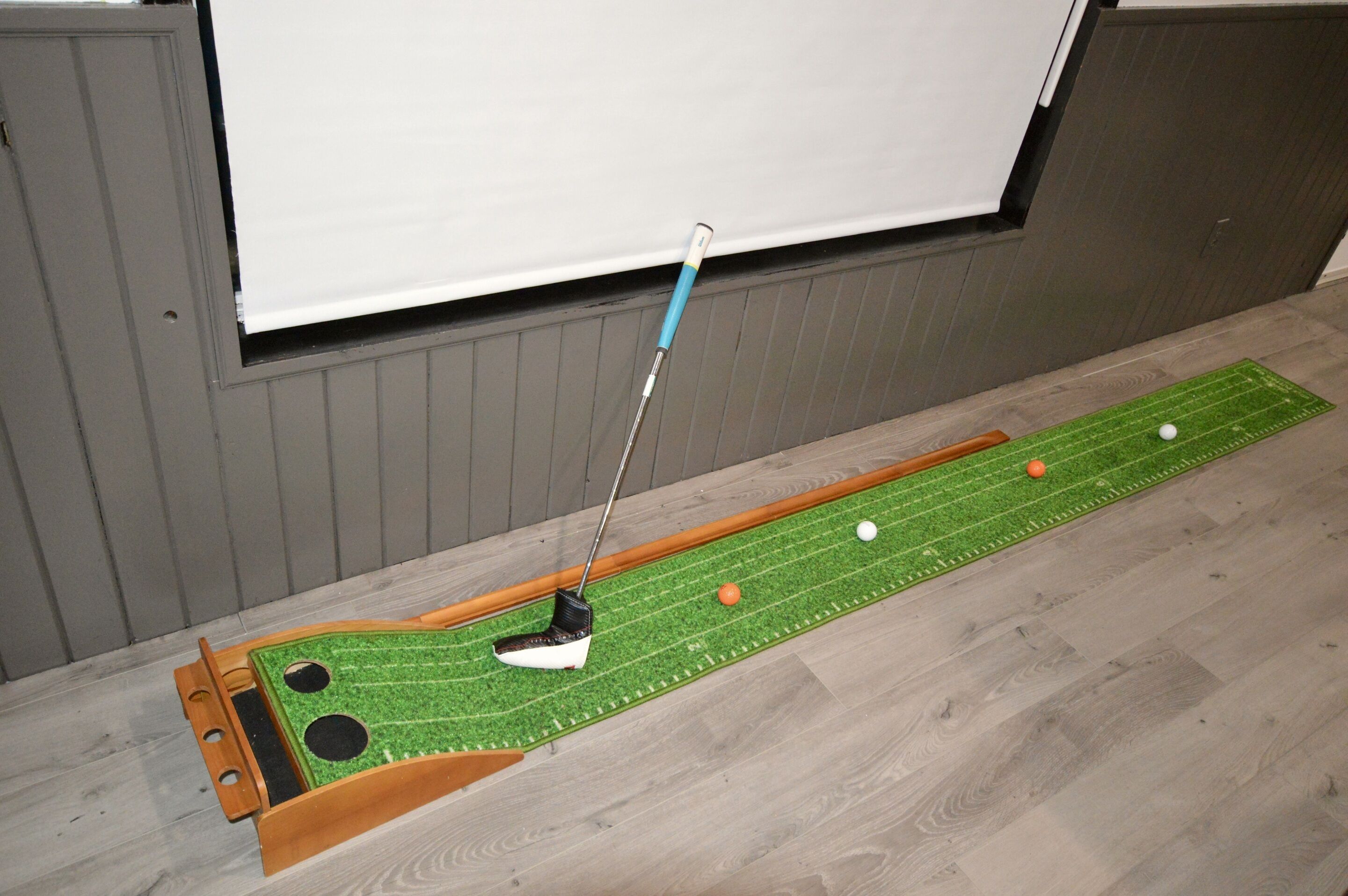 Een minigolfbaan met een putting green, een golfgat en een golfbal.