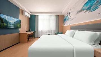 A hotel room with a large bed, a desk with a chair, a television, and a painting on the wall.