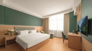 A hotel room with a bed, bedside table, chair, desk, and a TV. - Anqing Yixin Hotel (Anqing)