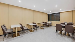 A conference room with tables and chairs, a large window, and a plain wall. - Anqing Yixin Hotel (Anqing)