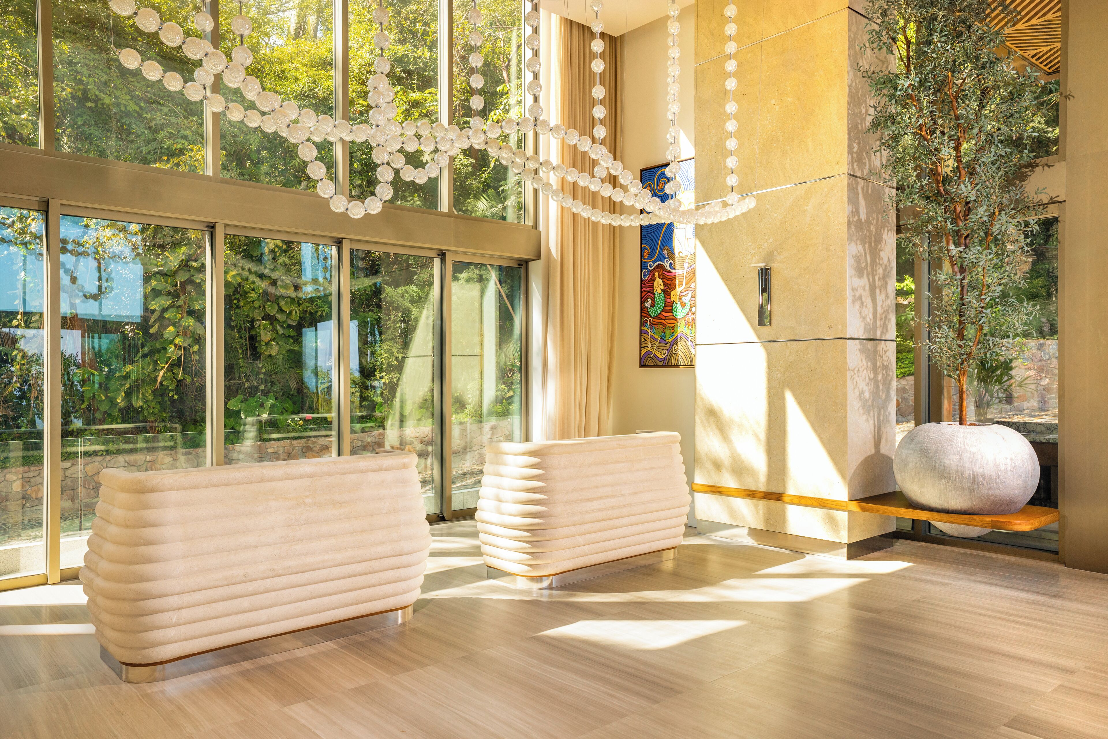 A modern interior with large windows, a decorative string of white spheres, and a large vase on a shelf.