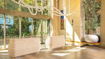 A modern interior with large windows, a decorative string of white spheres, and a large vase on a shelf.