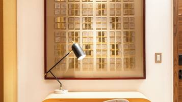 Un bureau moderne, avec une chaise, une lampe et un panneau décoratif au mur.