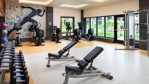 A gym with weight machines, cardio equipment, and a mural of a runner. - Tropical Comfort – 1BR Villa with Lanai at Sheraton Kaua‘i Resort (Koloa)