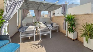 A covered outdoor seating area with a table and chairs, a potted plant, and a pergola structure. - Gorgeous home in Rojales (Rojales)