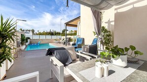 A poolside area with lounge chairs, a table, and potted plants. - Gorgeous home in Rojales (Rojales)