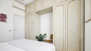 Una camera da letto con un letto, un armadio, una sedia e una pianta in vaso.