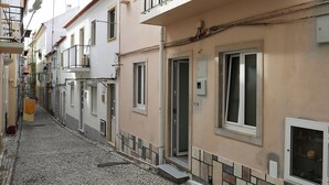 A narrow cobblestone street lined with buildings, featuring a mix of residential and commercial properties. - Sea & Sun Apartment II (Nazaré)