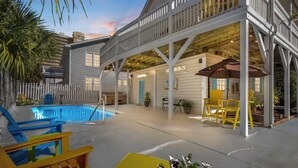 A pool area with a covered deck, outdoor seating, and a view of the pool. - Ocean Peek in Ocean Dr.  6-bedroom/6.5 bath house in lovely North Myrtle Beach (North Myrtle Beach)
