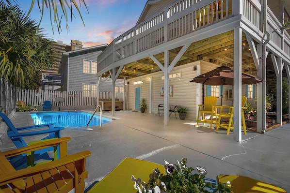 A pool area with a covered deck, outdoor seating, and a view of the pool. - Ocean Peek in Ocean Dr. 6-bedroom/6.5 bath house in lovely North Myrtle Beach (North Myrtle Beach)