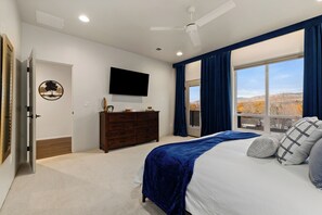 A bedroom with a bed, a dresser, a television, and a window with curtains. - Private game room, fire pit, and hot tub overlooking the foothills +  just minutes from downtown Boise (Boise)