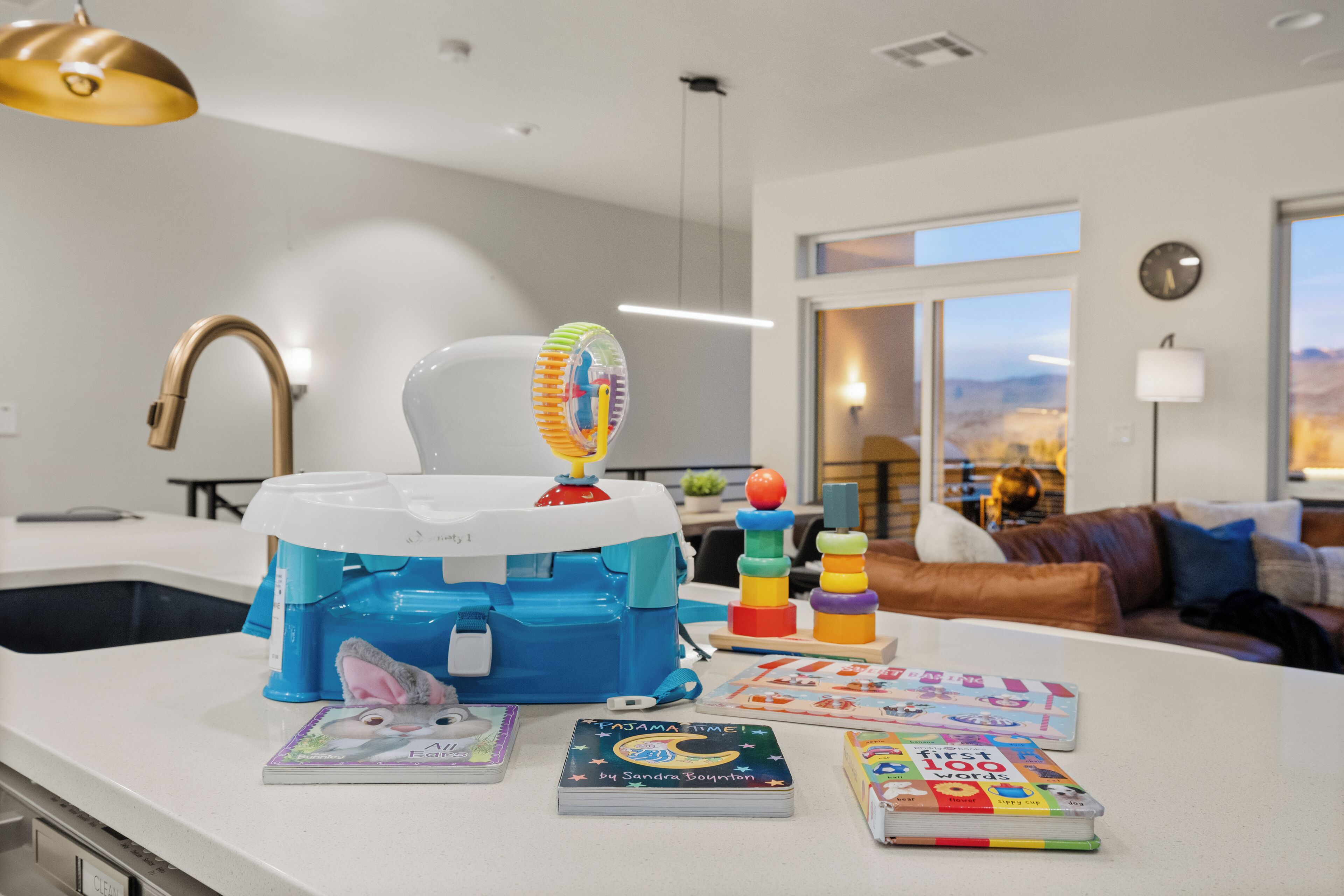 A kitchen with a white countertop, a blue and white water dispenser, and children's books.
