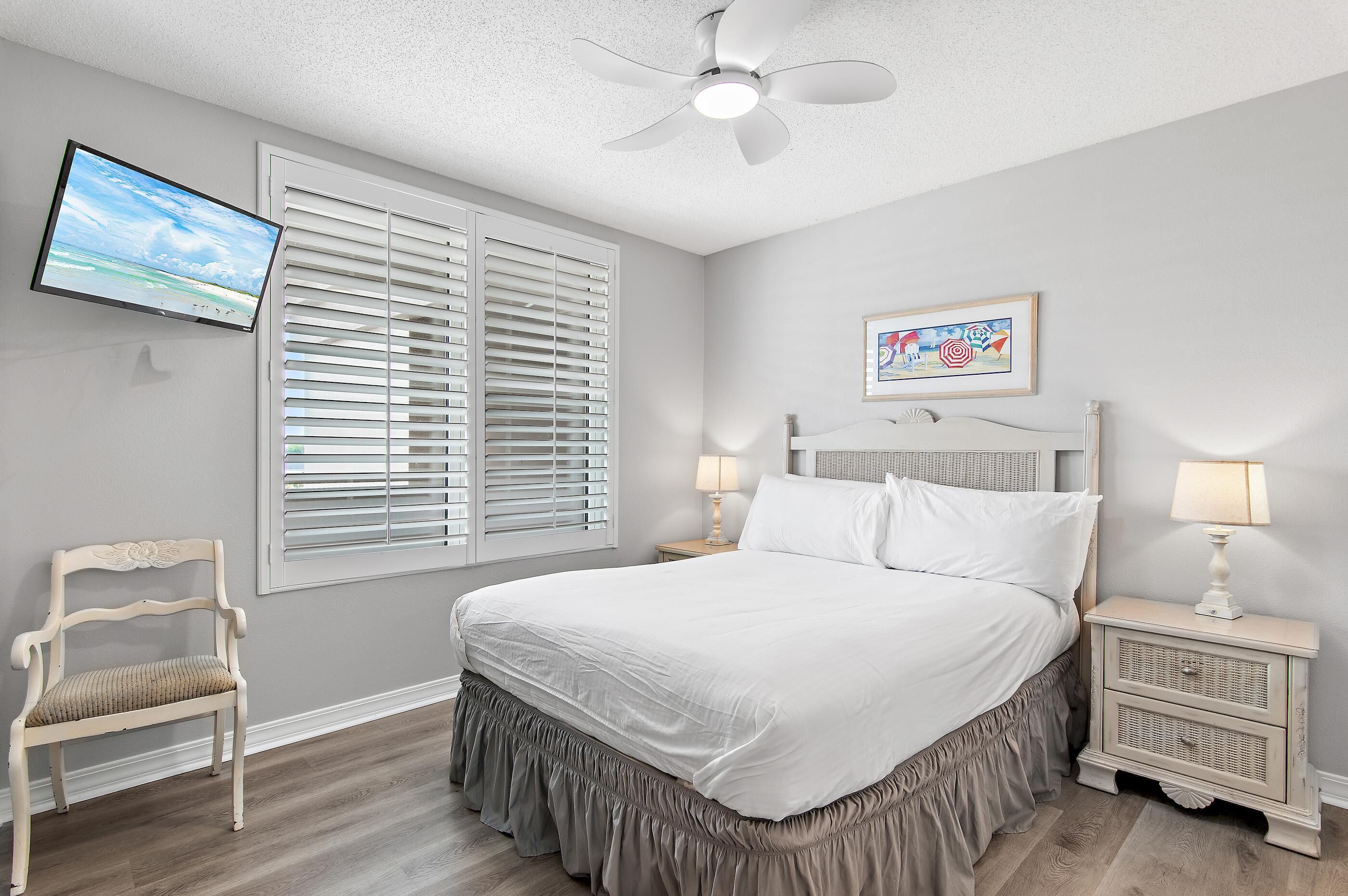 A bedroom with a bed, a TV, a chair, and a nightstand.