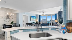 A modern kitchen with a large island, a built-in sink, and a view of the beach. - St. Lucia 1202 (Destin)