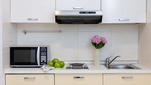Une cuisine moderne équipée d’un four à micro-ondes, d’un grille-pain, d’un évier et de placards.