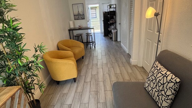 Un salon moderne avec un canapé, un coin repas et une cuisine en arrière-plan.