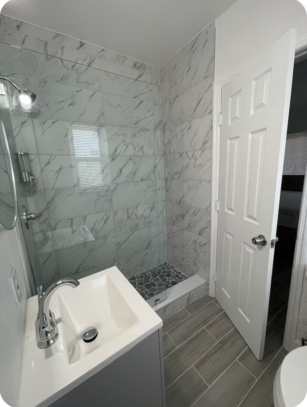 A bathroom with a shower, a sink, and a toilet.