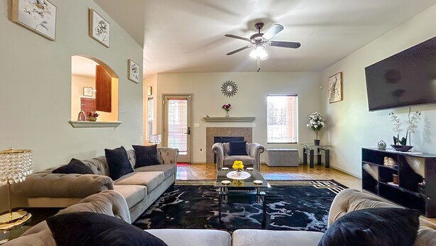 A living room with a sofa, a coffee table, and a fireplace. - Luxury Vacation Rental (Las Cruces)
