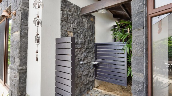 A stone wall with a wooden gate and a metal bell. - House in the Heavens with Panoramic Ocean Views (Playa Negra)