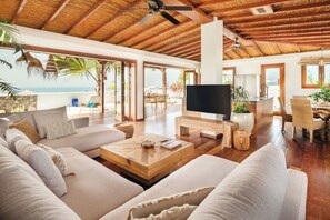 A spacious living area with a large TV, wooden coffee table, and comfortable seating. - HORIZON BALI by Buenavilla | An Oasis of peacefulness in Puerto del Carmen (Tías)