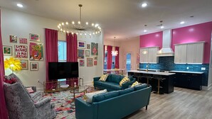 A modern living room with a sofa, TV, and artwork on the walls.