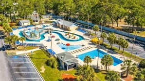 A resort with a large swimming pool, multiple lounge areas, and a parking lot. - 1st-Floor 2BR Condo | Myrtle Beach Resort | Pools, Waterpark & Beach | Sleeps 8 (Myrtle Beach)