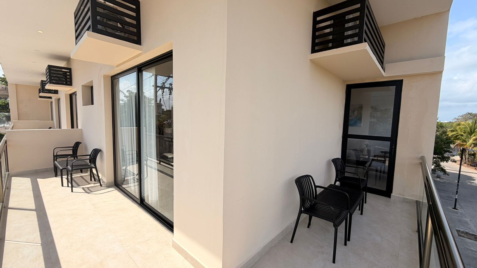 A balcony with a table and chairs, a glass door, and a railing.