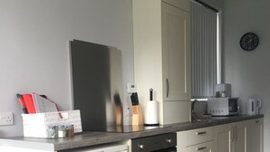 A modern kitchen with a dishwasher, oven, and white cabinets. - Traditional Family Home, Driveway & Gardens -  Preston, Samlesbury, M6, M55,M61, (Preston)