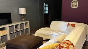 Une chambre moderne avec un grand lit, une télévision, des meubles de rangement et un élément décoratif mural.