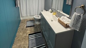 Une salle de bain équipée d’un WC, d’un lavabo, d’un miroir et d’un porte-serviettes.
